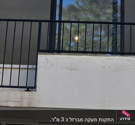 מרפסת עם מעקה מתכת שחור וחלון זכוכית גדול